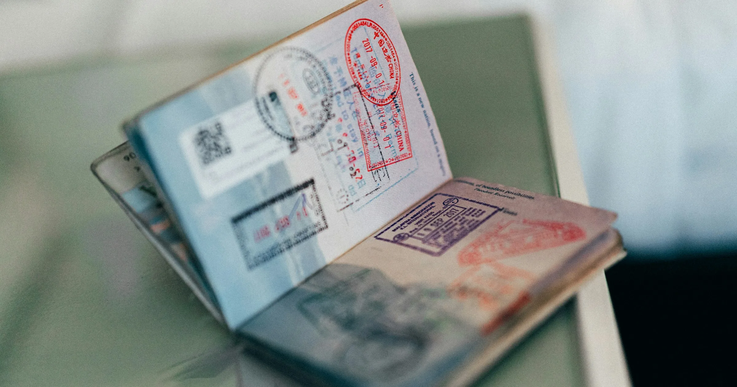 An open passport with entry stamps from several countries